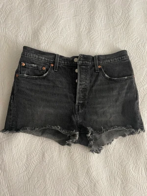 Svarta Levi’s shorts - Ett par snygga Levi’s shorts som är svarta men en lite grå tvätt. Storlek w29, M men sitter också riktigt snyggt om man är S då de blir lite oversized. 