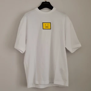 ACNE STUDIOS TSHIRT  - Acne Studios tshirt in white with a yellow "lagom" face patch. New condition! Boxy oversized fit, really comfortable! Fit xxs-m depending on what fit you want. Bought at sample sale so there is a mark in the label, see 3rd photo 