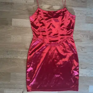 En röd satin klänning från H&M.  Storlek S. Bara använd 1 gång så den är i nyskick. Säljer pga för kort på mig (jag är 1.64). Köparen står för frakt. Kan även mötas upp i Varberg. 