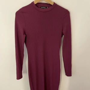 Lång klänning  - Lång klänning från boohoo. Den är typ plommon färgad, mer åt de lila hållet. Den kommer till mina knän å då är jag 1,78m lång. 