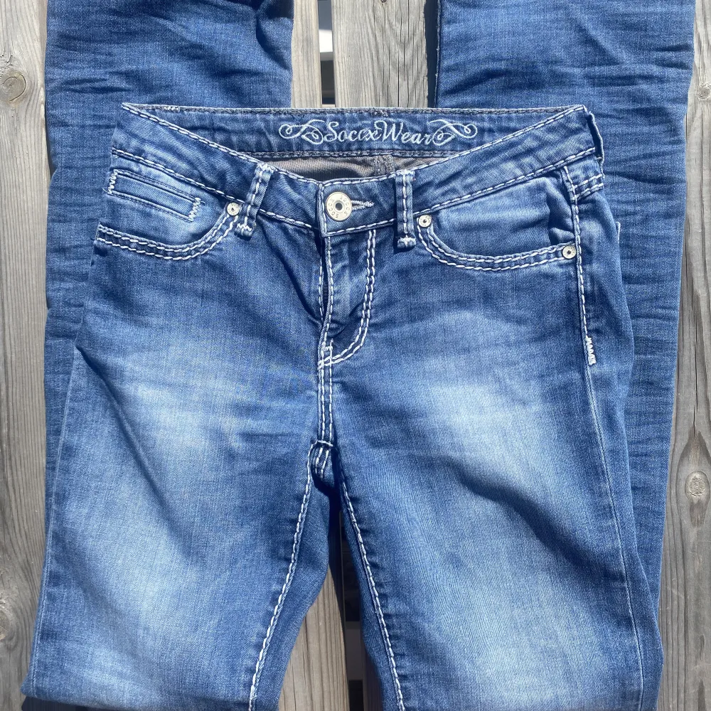 Skitsnygga lågmidjade jeans med snygga detaljer från märket soccx som påminner om true religion jeans, köpta secondhand men i nyskick. passar bra på mig som är 165 men skulle även pass kortare (160-165) som brukar ha stl 34/36. Köparen står för frakt💗💗. Jeans & Byxor.