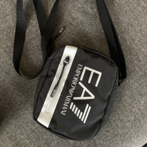 Armani väska  - Manbag, becknarvästa, axelremsväska  Kärt barn har många namn. Säljer denna då jag har tröttnat på den.  Använt men bra skick, nästan som ny  Köpt för 899kr Säljer för 500kr
