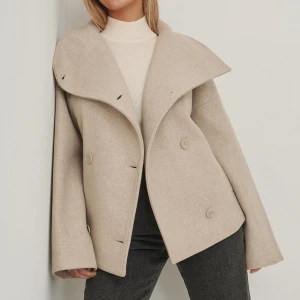 Beige kappa - Säljer min fina kappa från NA-KD som är helt slutsåld, köptes förra året och använd någon gång. En knapp håller på att trilla av men det kan man lätt sy tillbaka! Lite nopprig. I storlek 36 men passar mig som brukar ha 40. Hör av er vid intresse💓