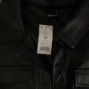 Top - Väldigt snygg top i skinmsterial. Aldrig använd med etikett kvar. Strl: xs 