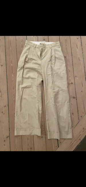 Byxor beiga - Beiga oanvända, för tighta i midjan på mig.  Faller snyggt. Strl 38