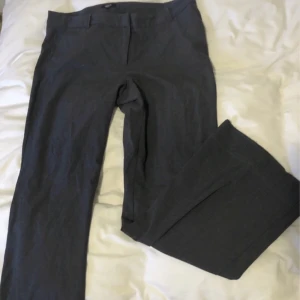 Gråa vida kostymbyxor  - Kostymbyxor i gott skick, storlek 46, från vintage märket Amys Stories. Midja: 50-53cm x2. Innerbenslängd: 80cm. Materialet är lite stretchigt. Finns inga bilder på men Dma gärna vid andra frågor eller funderingar! Köparen står för frakt.