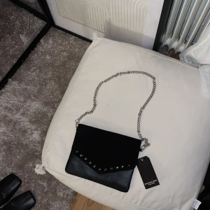 Kuvert väska med nitar - Jätte fin kuvert väska som tyvärr inte kommit till användning, helt oanvänd med prislapp kvar! Perfekt till utekvällar och middagar.