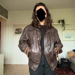 Skinnjacka  - Brun skinnjacka köpt på secondhand för 800kr! Så snygg nu i höst!🍂☕️ I jackan står det storlek 58. Den har några små vita fläckar på armen (bild 3) och en knappt synlig fläck på ryggen. Jackan kan behöva vädras då den har kvar en del doft från butiken!💐