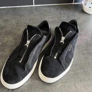 Arigato clean 90 zip  - Säljer mina arigato laceless med dragkedja i nyskick i storlek 41. Köpt för en månad sen i Stockholm på arigatos affär.  Allt finns box och påse och skorna är använda ungefär 5 gånger! Tvivla inte på att höra av er vid funderingar! Pris kan diskuteras.