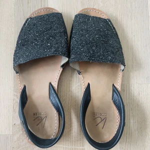 Sandaler från K.Cobler storlek 38 - Märke: K.Cobler Vad: Sandaler Storlek: 38 Upplevd i storlek: Normal Färg: Svarta/glittriga  Skick: Använda, men inget att anmärka på
