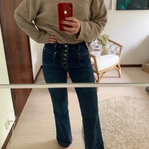 Högmidjade jeans med knappar på framsidan, storlek W31 och L32 och passar mig som är storlek 36-38 i byxor och 168 cm.