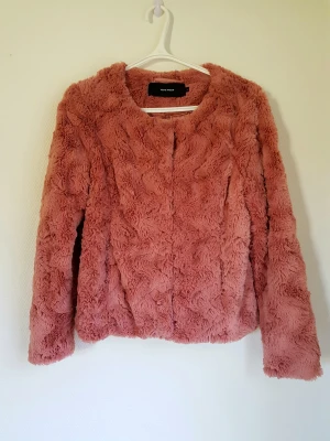 Rosa (pälsjacka) - Rosa pälsjacka (fake päls) från Vero Moda i storlek M. Använd endast en gång och därmed i nyskick. Finns inga tecken på användning.