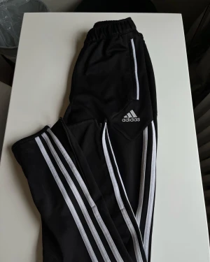 Adidas byxor  - Adidas byxor med dragkedja nedtill foten. Storlek 152 