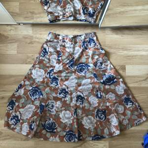Vintage blommig 70-tals kjol. Aldrig använd och köpt på second hand. Står ingen storlek men längd: 62 cm och midjemått: 31 cm