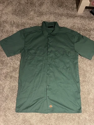 Skjorta från dickies. - Grön dickies skjorta, lång och skön.  Använd 2 gånger. Storlek : S, herr. Original pris: 600kr Säljs för 500kr, spara 100kr.