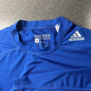 Långärmad träningströja - En blå kompressionströja från Adidas i storlek S. Skönt material och i mycket bra skick!
