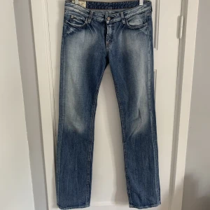 Lågmidjade blåa jeans - Säljer dessa väldigt fina jeansen då jag tyvärr inte går på mig dem. Hittar inte någon storlek på dem men skulle säga att de passar någon som bär xs/s. Lågmidjade och raka i modellen. Innerbenslängden på på dem är ca 82cm. Väldigt fint skick.