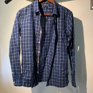 Skjorta ifrån Tommy Hilfiger - Skjorta i blått från märket Tommy hilfiger. Snyggt rutmönster.