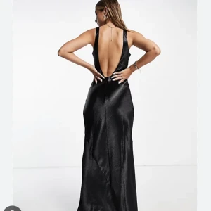 Fin klänning  - En fin klänning i blankt svart sidentyg. Den är djup i ryggen och sitter som en dröm runt kroppen! Endast använd på en finsittning så är så gott som ny. 