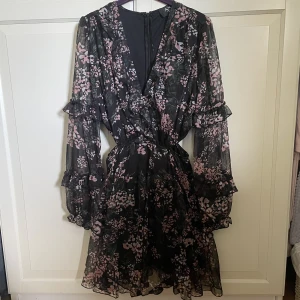 Volangklänning med cutouts  - Väldigt fin festklänning med cutouts i midjan för att framhäva figuren. 