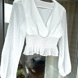 Blus - Säljer en vit blus med v ringning, samt resår under bysten. Sparsamt använd, fint skick. Färg: Vit Storlek: S