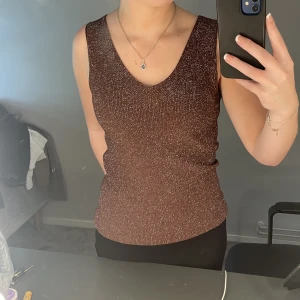 Brun glittrig topp - Jag säljer det här linnet som är brunt och glittrigt i storlek m men passar även mig som vanligtvis har s!💗🙌