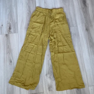 Linnebyxor  - Ett par senapsgula byxor i linne liknande material. Vänligt tunnt och floowit. Köpta på bonpix men kommer inte till användning. Andvänts 1 gång 