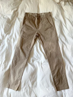 Ralph Lauren chinos beige 28x32 - Beiga chinos från Ralph Lauren Denim & Supply, väldigt fint skick. Strl 28 x 32. Är original 34 långa men är uppsydda, se bild 3. 28 i midja men passar mig som har 29 vanligtvis.