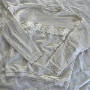 Sweatshirt  - Supersöt vit sweatshirt med volang och broderi detaljer. Från det spanska märket Lefties. Storlek 152 men skulle säga att den passar en Xs-s. 100kr.