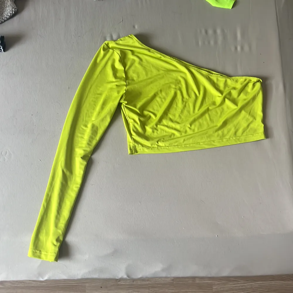 Neon topp med en arm Använd en gång. Toppar.