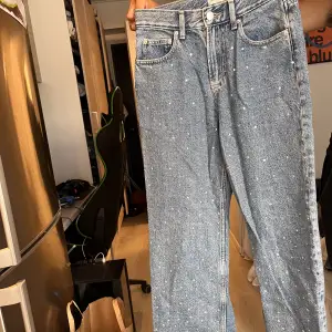 Jeans som är medelhöga i midjan med små diamantstenar längst benen. Köpta till nyår och endast använda en gång. Väldigt coola och unika jeans! Skulle säga att de är lite stora i storleken. 