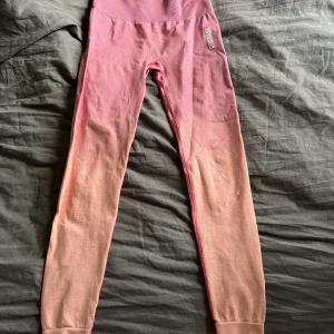 Träningstights från gymshark  - Snygga träningstights från gymshark i en snygg rida/orange ombrefärg. Storlek S och är i fint skick 