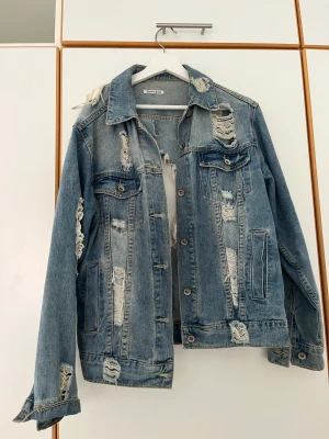 Jeansjacka i storlek M/L - Säljer min jeansjacka i storlek M/L. Funkar som både oversize och vanlig passform. Det slitna och de hål som finns ska vara där, va så när jag köpte den.  Pris: 150kr