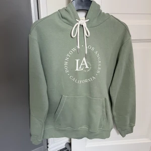 Hoodie  - Grön hoodie i storlek XS från h&m. Använd någon enstaka gång i väldigt bra skick. 60kr plus frakt. Har mycket fler plagg ute tillsalu! 