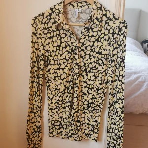 Mönstrad Skjorta, & other stories - Figursydd, stretchig skjortmodell i 100% viskos från & other stories. Mönster i beige, gul och svart. Fintvätt 30 grader. Storlek 36. Använd, men ej trasig på något sätt. 