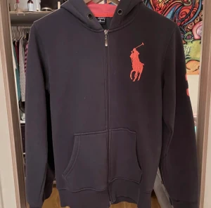 Polo zip up - Tvär fet polo zip up som jag köpte här på plick.(bilder är från förra säljaren) Säljer då den inte passade mig. Den ser orange aktig ut på bilden men är rosa.