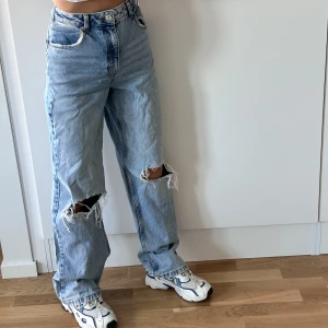 jeans - Blåa raka/lätt utsvägnda högmidjade-jeans med hål vid knäskålarna från NAKD. Storlek 36 men är smalare i midjan så de passar bättre storlek 34! De är i nyskick 😊 Hör av dig om du undrar något☺️✨🤍👋🏼
