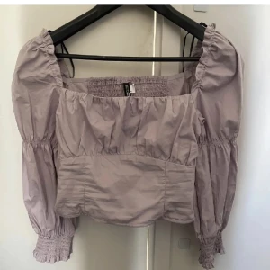 Tröja - Ljuslila tröja ifrån hm, aldrig använt, bara testat. Är i stretch material pp hela ryggen och har pösiga/stora armar. Sitter tajt runt magen. 