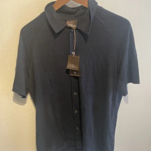 Oscar jackbson linne skjorta - Skjortan är i storlek s, mörkblå i mamterialet linne, HELT OANVÄND med prislapp kvar kostar ny 1800kr,  Billig pga felköp rea.