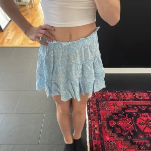 Blommig kjol - Jättegullig blå kjol men vita blommor på som tyvärr kommer inte till användning längre