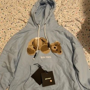 Palm angels Teddy bear hoodie unvirsety blue - Min helt nya Palm angels Hoddie som jag fick i present gillade inte passformen eftersom den är rätt så stor vi arm rummet och är designad så kvitto finns tyvärr inte. SVÅR ATT FÅ TAG PÅ. Ny pris 5000-6000