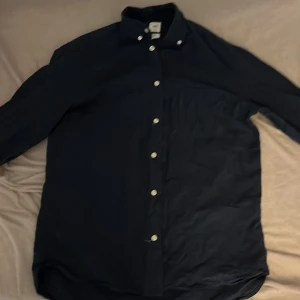 Linne skjorta - En mörk blå linne skjorta som är lite skrynklig men går att fixa med ett strykjärn. Den är i ett bra skick. 