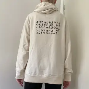 Hoodie från lager 157 i storlek L. Använd fåtal gånger därav nyskick. Säljer pga att den inte används. Liten text på framsidan och större text på ryggen. Vet inte vad de betyder.