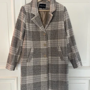 Kappa - En superfin rutig kappa ifrån Happy Holly. Använt 2 ggr & är i nyskick. Storlek 36/38 Går i beigea toner.