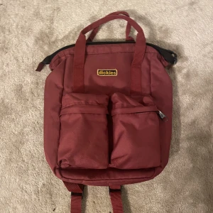 Snygg Dickies Ryggsäck - Jättefin Dickies ryggsäck köpt på Carlings för några år sedan men används inte längre.  Liten men rymlig, rymmer en macbook 13”(se bild). Har vadderat datafack,  gömt fack på ryggen samt två stycken fack fram.  Fint skick, inga fläckar.  Nypris 560kr