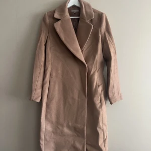 Beige kappa  - Använt en del gånger men är i bra skick.  Slutar under knäna. 