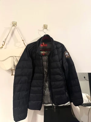Parajumpers jacka - En parajumper för herr. Står som L men tror den passar mer som en M.  Väldigt bra skick, endast används 1 år. Den är inte svart, utan lite åt det blåa hållet.