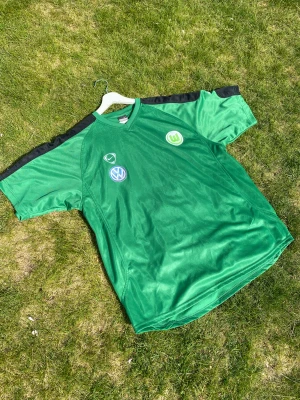 Wolfsburg träningströja 2005/06 - Wolfsburgs träningsströja från 2005-06 Storlek: Large Skick: 5/10 Wolkswagen märket har lite defekter. Frågor? Skicka till mig. 