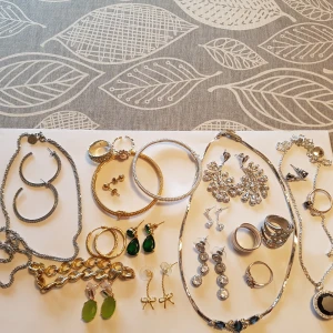 Paket med smycken i guld & silver - Smycken i guld och silver. Det mesta är helt nytt. Två av silverringarna har legat i en låda länge, och kam därför behöva putsas.  Paketet innehåller: 3 st halsband 3 st armband 10 par örhängen 5 st ringar  Frakten ingår i priset 🙂