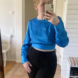 Blå topp med öppen rygg  - Superfin blå topp med öppen rygg. Aldrig använd. Otrolig färg och skönt tyg. Storlek L men jag har oftast storlek S/M i toppar och den funkar bra ändå.